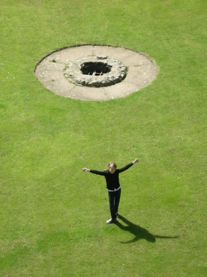 a person standing on top of a lush green field