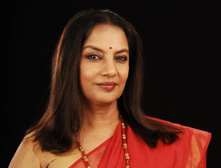 a woman is smiling wearing a necklace and dress