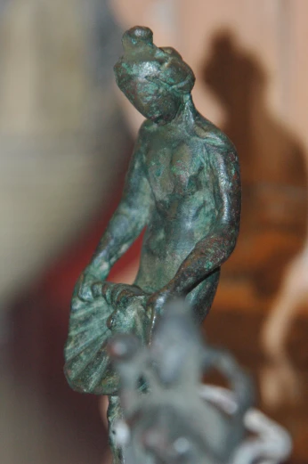 a bronze figure is shown in front of a background