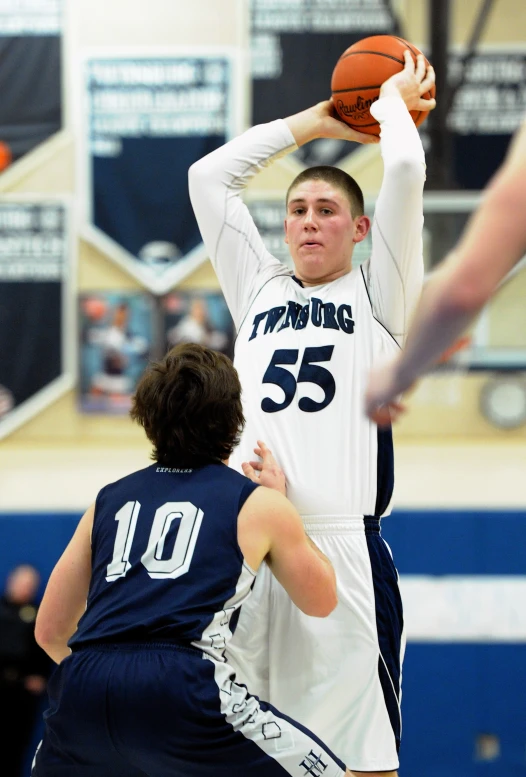 young men playing basketball in a gym on the court