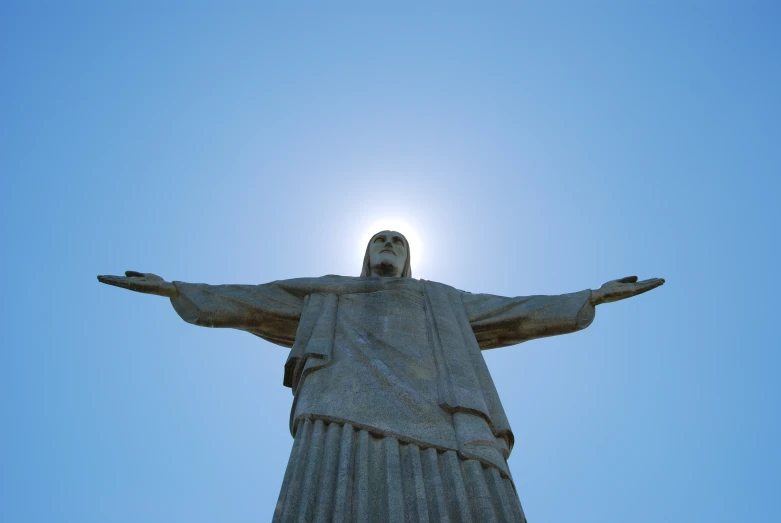 a statue of jesus with a blue sky behind it