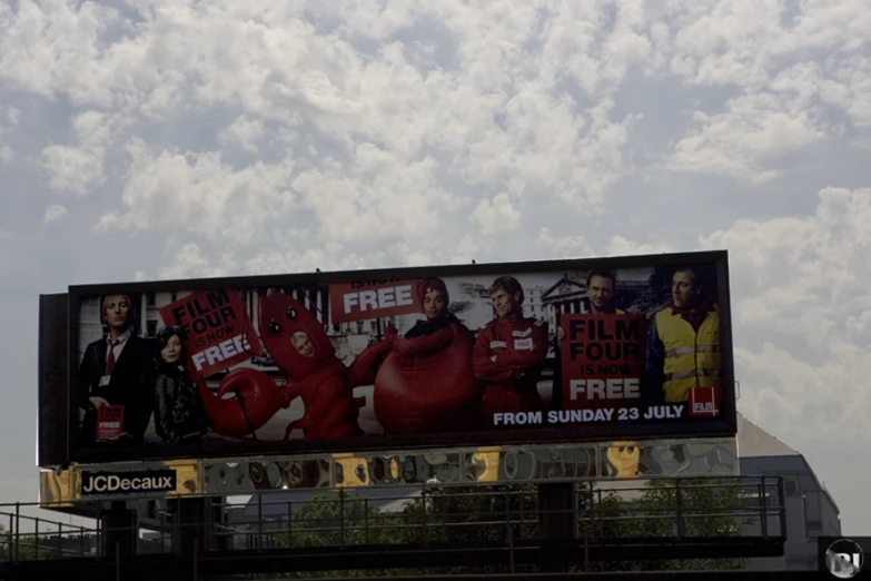 large billboard on the side of a building with film characters hanging off it