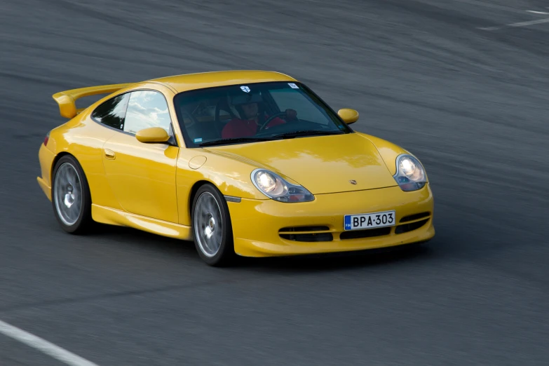 a yellow sports car racing down a track