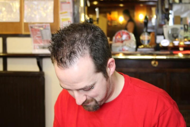 a man with a shaved head at a table