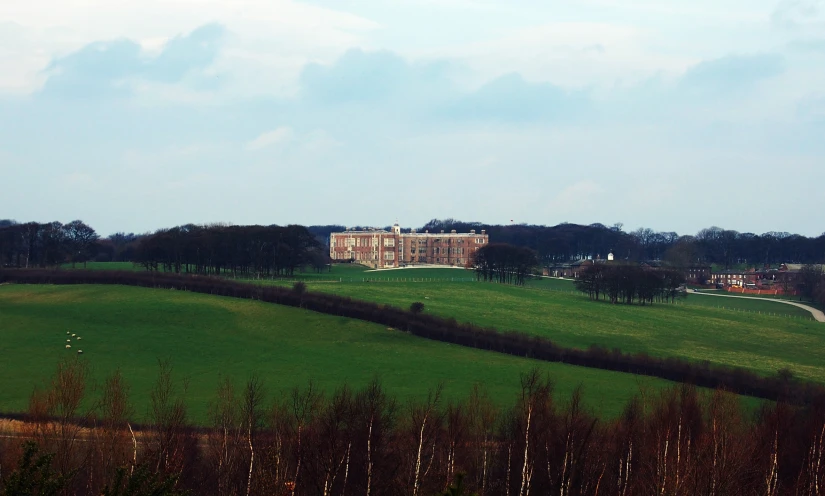 large house sitting next to green trees in the countryside