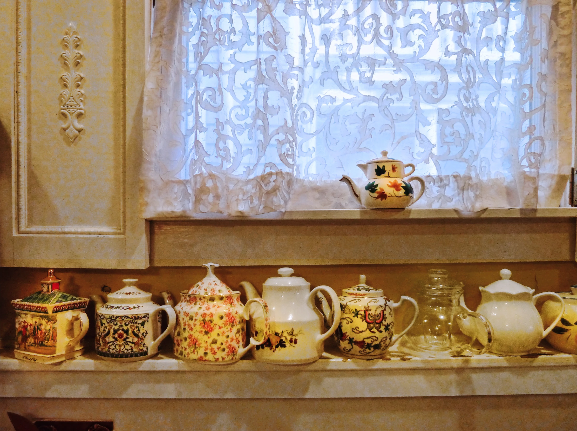 a window and shelf covered in tea pots, jars, vases and tea bags