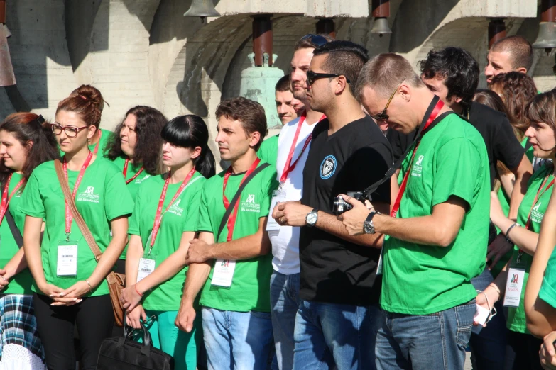 a group of people are wearing green shirts