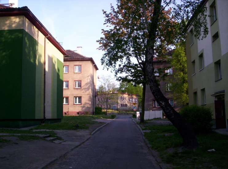 a small road is flanked by two buildings