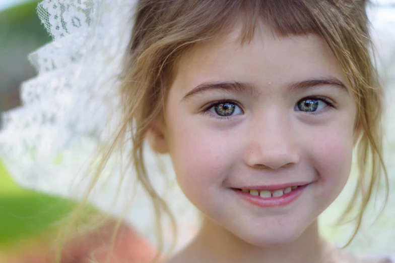 a little girl smiling under an umbrella