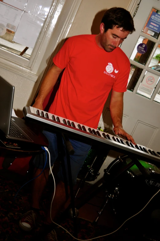 a man in red is playing a keyboard