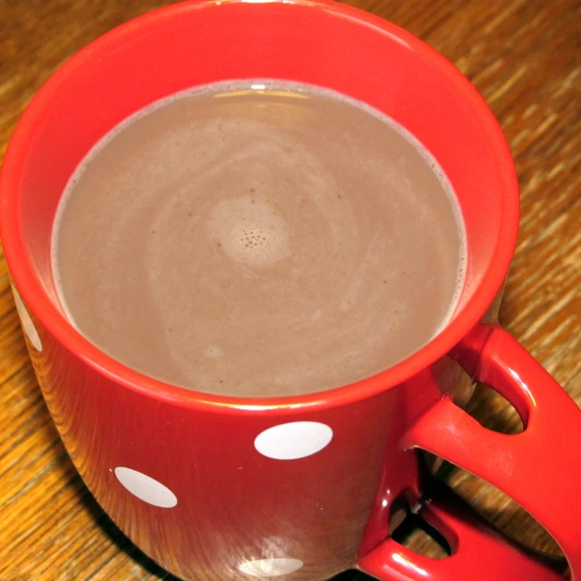 a mug of  chocolate sitting on top of a wooden table