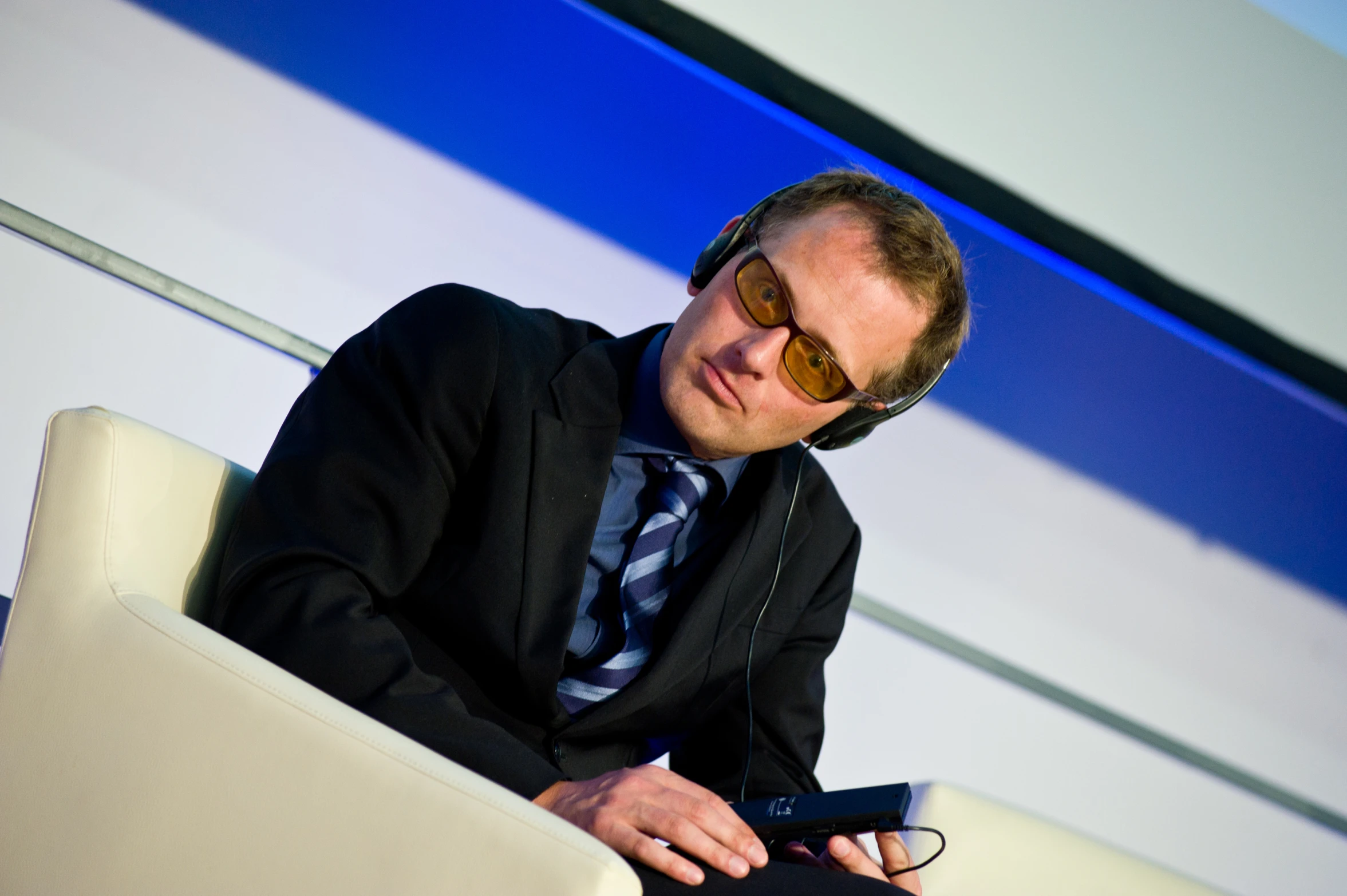 man in business attire sitting down holding a computer mouse