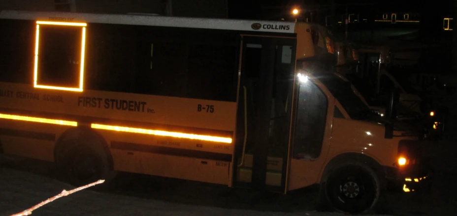 a yellow light on the side of a bus at night