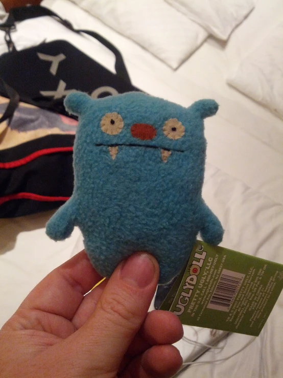 a person holding a small blue monster