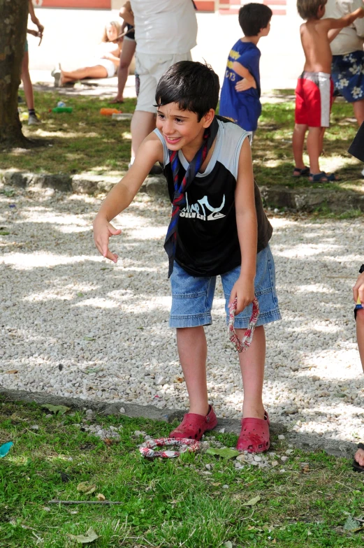 a little boy holding a baseball glove while standing in the grass