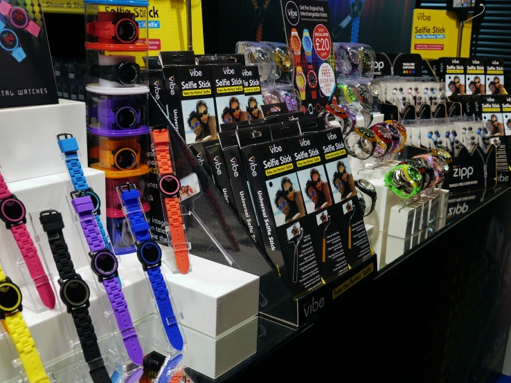 several different colors of wrist watches and sunglasses on display