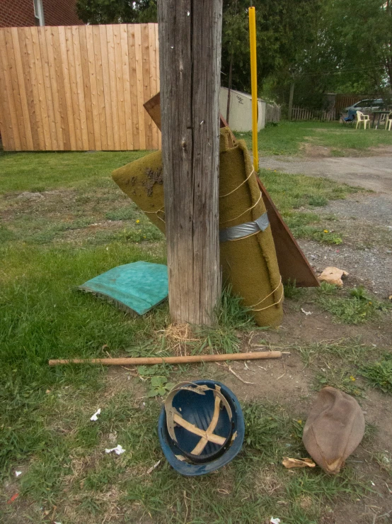 a large wooden pole sitting next to a blue and yellow bucket