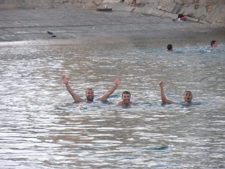four men who are swimming together in the water