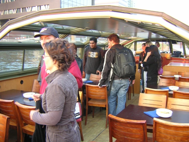 people in front of a wooden covered boat traveling along water