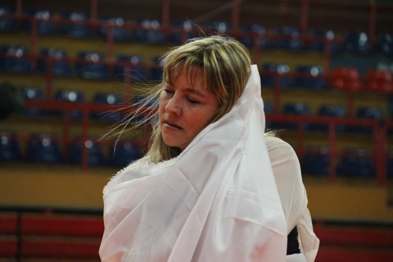 a woman wearing a long white veil in front of the crowd