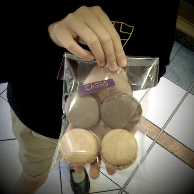 a person opening up a case of cookies with a package around it