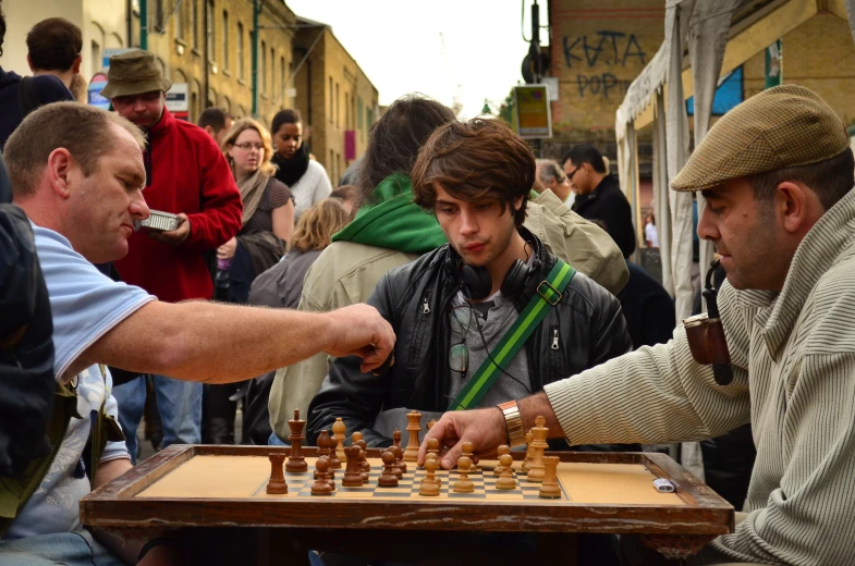 a group of men playing a game of chess on the street