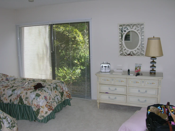 a bedroom with two beds, dresser and a mirror