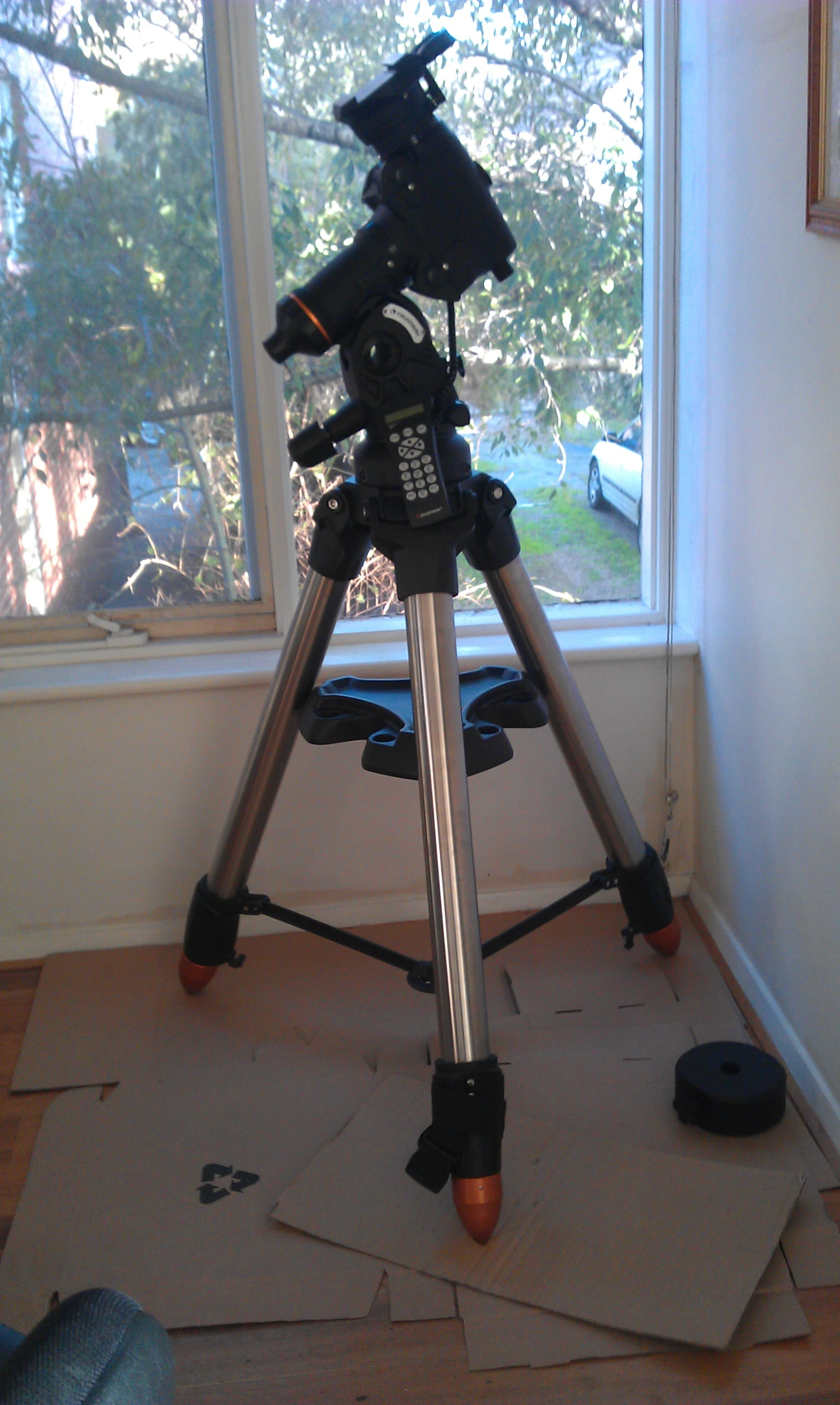 a telescope sits on a stand in the corner