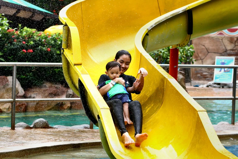 woman and child playing on slides in water park