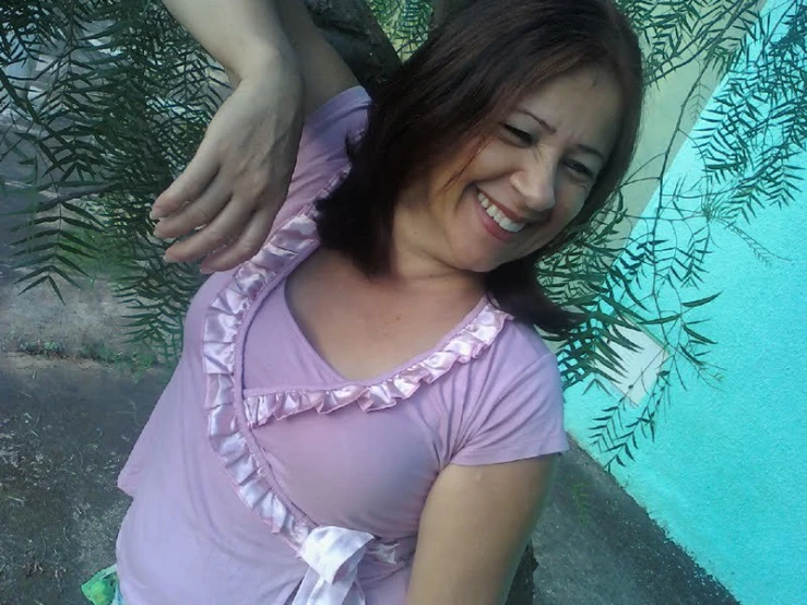 a women sitting next to a blue pool smiling