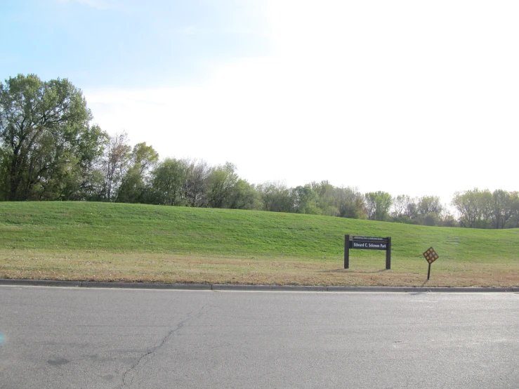 the street is empty and there is a very short sign next to it