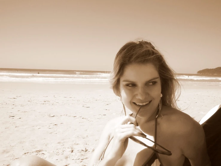 a young woman on the beach brushing her teeth