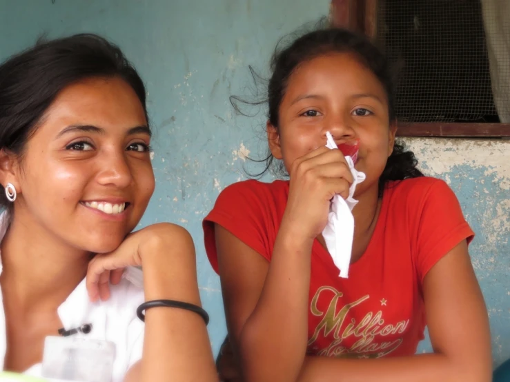 two s sitting outside eating soing from a white plate