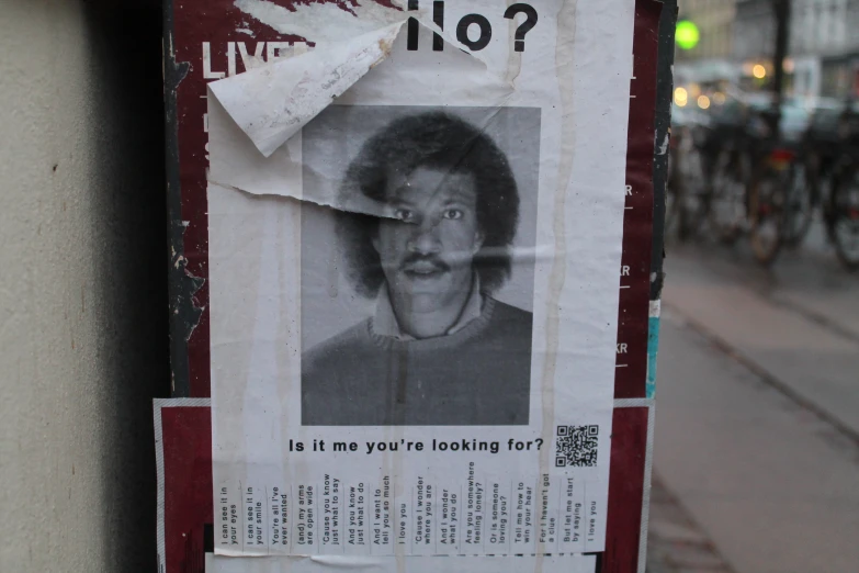 a newspaper ad on a city street that has a picture of an older man