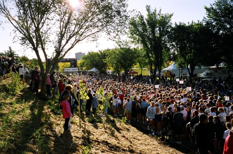 there is a large crowd of people gathered in the field to hear about soing