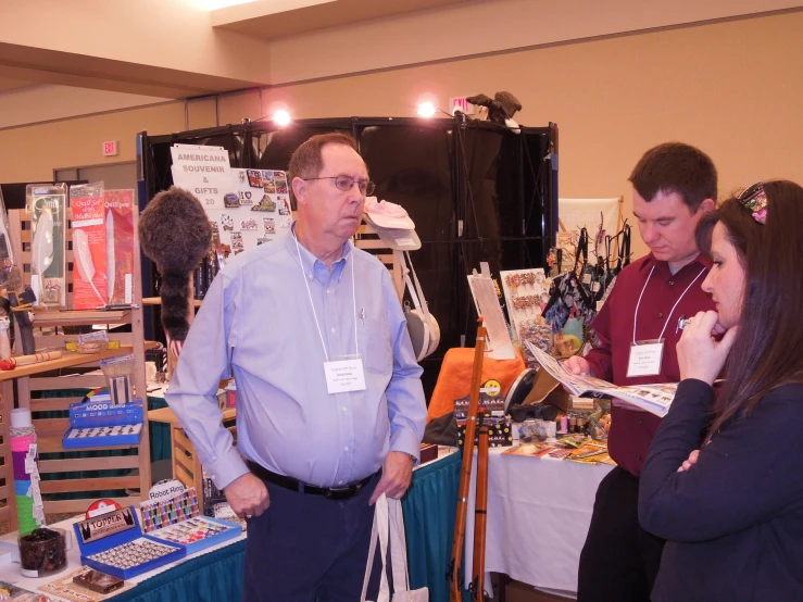 two women and an old man are shopping at an antique show