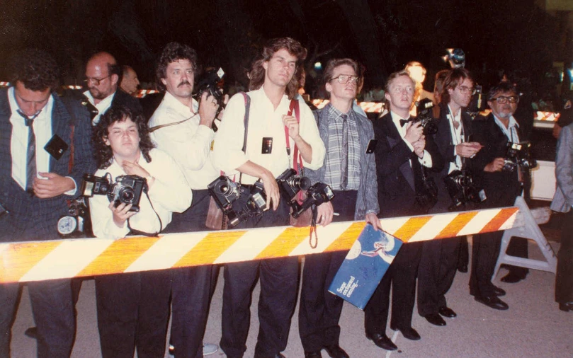 people standing next to the large white striped barricade