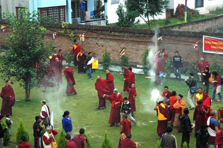 many people in red robes standing in front of a crowd of monks