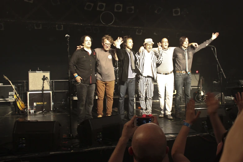 several guys and one man singing on stage