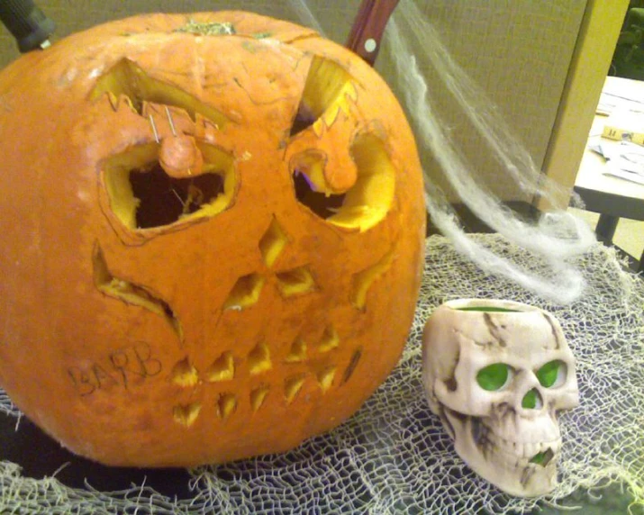 a halloween pumpkin and a skull head are sitting on a table