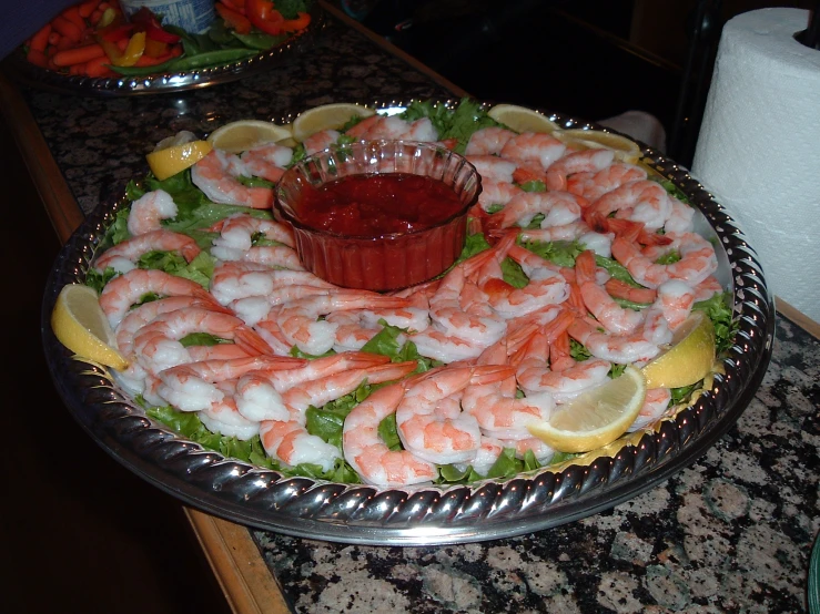 this platter has shrimp, lettuce and lemon slices on it