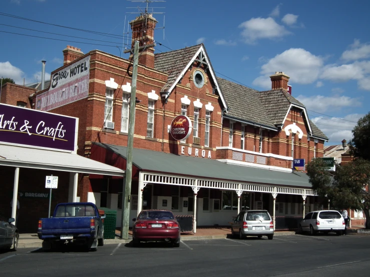 a red brick building next to several cars in front