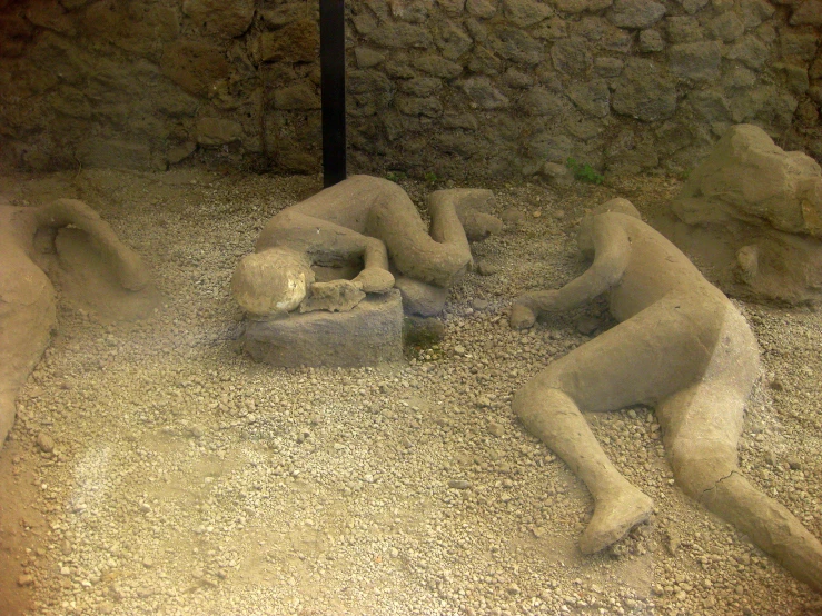 two human sculptures in a display in a cave
