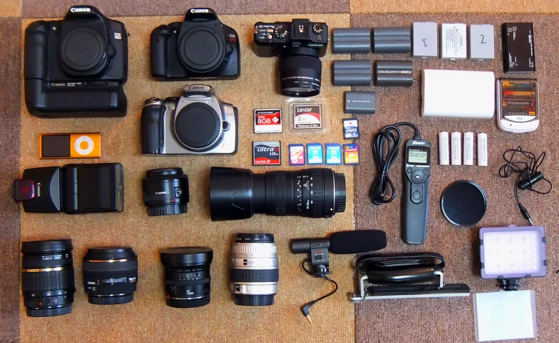 camera accessories and gadgets are laid out on a wooden table