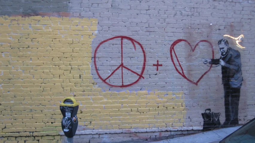 graffiti on the wall shows a man hing a peace sign