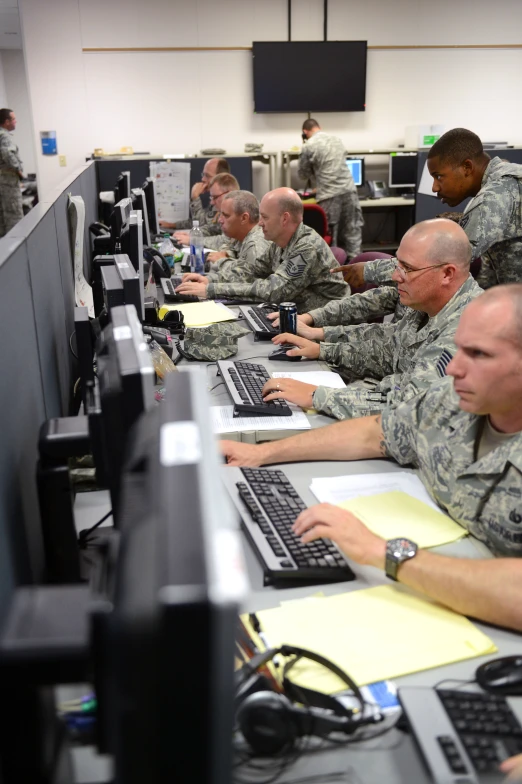 the service men are working on computers in the room