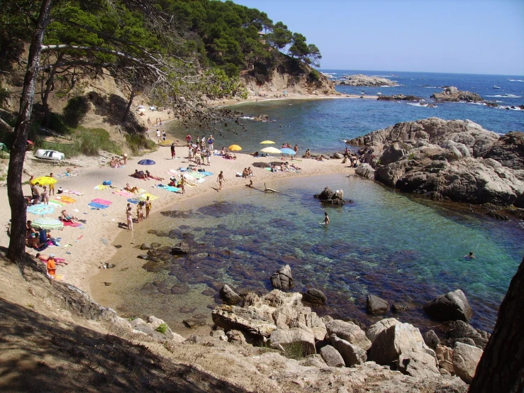 people are on the beach near some water