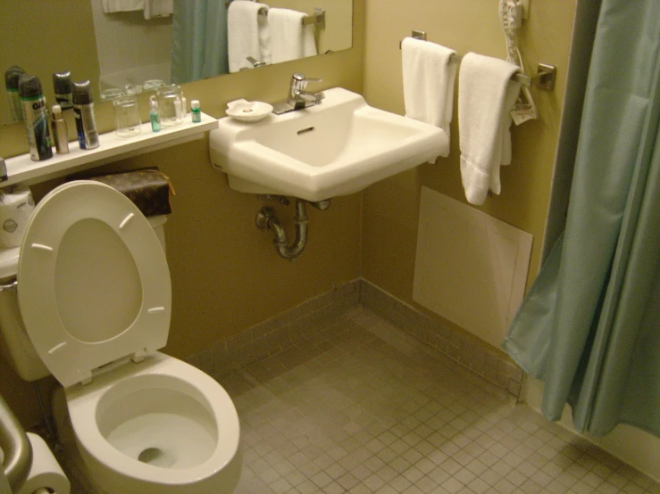 an older toilet with the lid down sits next to a sink in the bathroom