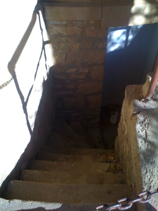 stairs leading down a steep stone staircase, next to a gate