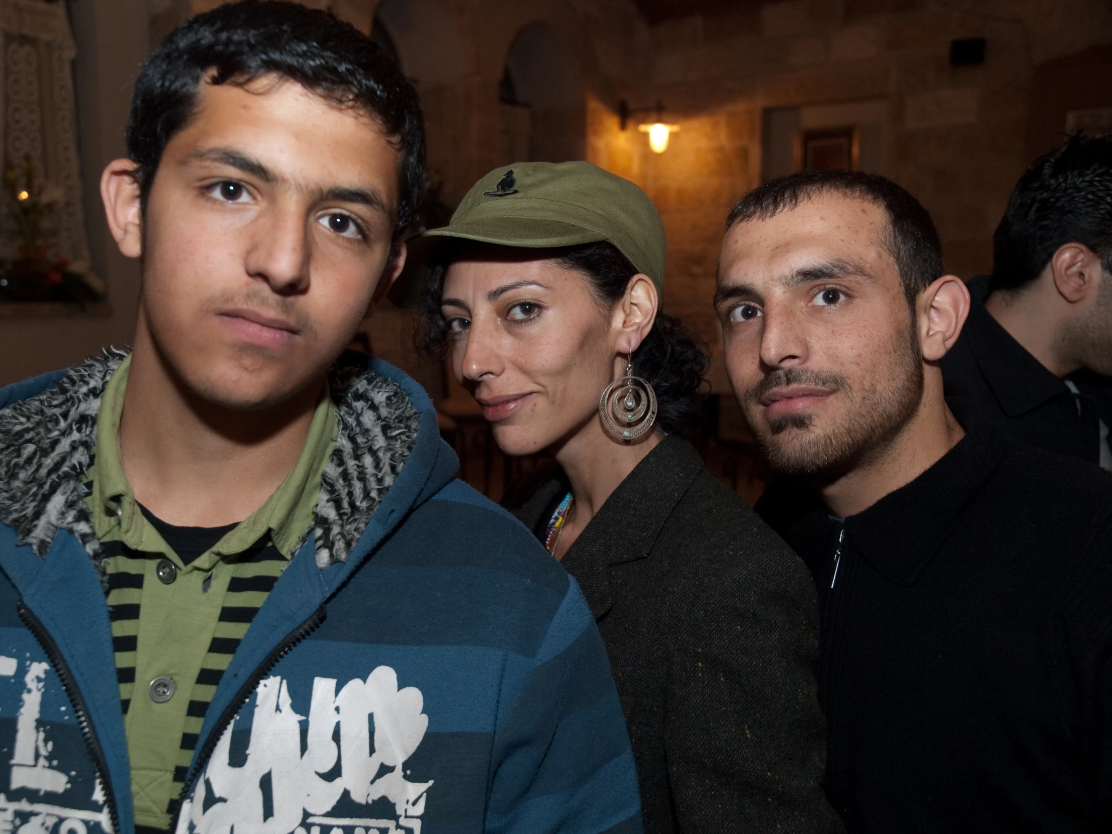 three people stand together, all looking into the camera